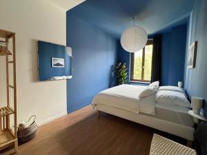 a blue bedroom with a bed and a window at Atelier Noé NOIR - Kunstvoll Wohnen - Wunderbares Frühstück möglich - Ruhig und nah am Zentrum - in Chemnitz