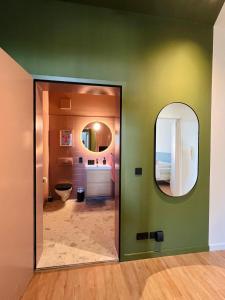 a bathroom with a green wall and a mirror at Atelier Noé NOIR - Kunstvoll Wohnen - Wunderbares Frühstück möglich - Ruhig und nah am Zentrum - in Chemnitz