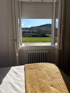 a bedroom with a bed and a large window at El pisito de Cris y Mia in Ponferrada