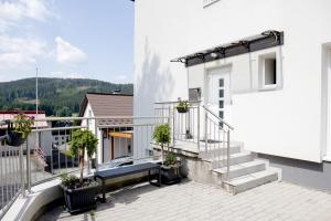un balcón de un edificio blanco con macetas en HunGasthaus 01, en Mariazell