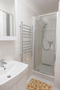 Un baño blanco con ducha y lavabo. en HunGasthaus 01, en Mariazell