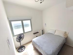 una camera da letto bianca con un letto e una finestra di Aisha Alojamiento a Salta