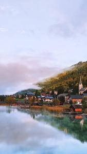 a small town next to a large body of water at SeeHotel & SeeApartments Kärntnerhof- direkt am See! in Weissensee
