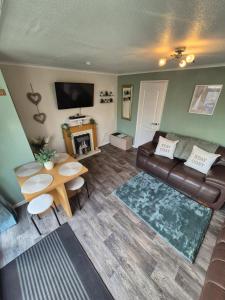 a living room with a couch and a table at Chalet 81 South Shore Bridlington 2x Bedroom Detached Chalet Sleeps 4 in Bessingby