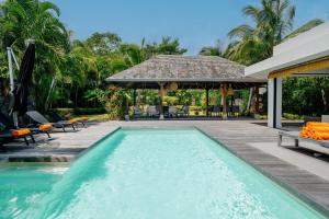 une piscine à côté d'un patio avec un gazebo dans l'établissement VILLA BRABANT - West Coast, Private Villas Resort, à Rivière Noire