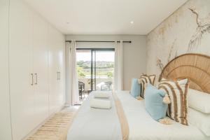a bedroom with a large bed with blue pillows at Lovemore Retreat - Port Elizabeth in Gqeberha +28 photos