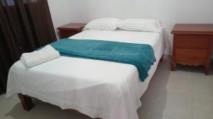 - une chambre avec un lit blanc et une couverture verte dans l'établissement Villa Josefa en Villas Camino Real cerca de las dunas de Chachalacas, à Ursulo Galván