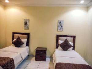 a room with two beds and a night stand at الغبيشى بلازا in Jeddah +43 photos