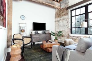 a living room with a couch and a tv at The Luzianne in New Orleans