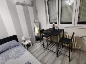 a bedroom with a table and chairs and a bed at Studio apartman Nataly in Kruševac