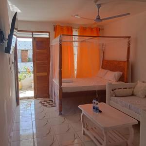 a room with a bed and a couch and a table at Watamu Plaza Studio 3 in Watamu