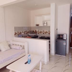 a living room with a couch and a table and a kitchen at Watamu Plaza Studio 3 in Watamu