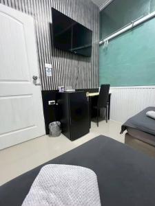a room with a desk and a tv on a wall at Future Hostel Pattaya in Nong Prue +22 photos
