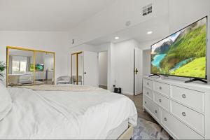 a bedroom with a large white bed and a large screen tv at Modern Private 3B-2BA Home and Spacious Yard in Lancaster