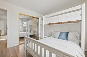 a white bedroom with a bunk bed and a mirror at Modern Private 3B-2BA Home and Spacious Yard in Lancaster
