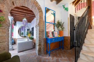 a hallway with a blue table and a mirror at Apartamentos - PinkSparrow - in Granada