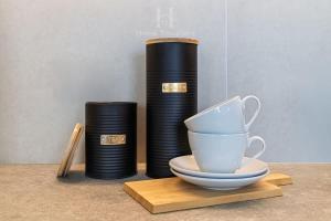a table with two stacks of black plates and a cup at HT A pasos de Alto Las Condes con Estacionamiento in Santiago