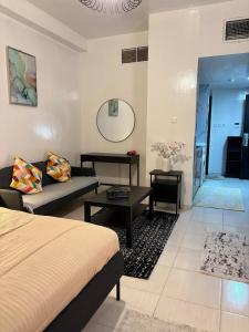 阿吉曼Studio in Ajman Corniche的一间有床、沙发和桌子的房间 更多14张照片