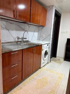 a kitchen with a sink and a washing machine at Studio in Ajman Corniche in Ajman  +14 photos