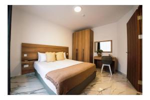ein Schlafzimmer mit einem großen Bett und einem Schreibtisch in der Unterkunft Exclusive Corner Penthouse with Large Terrace - by HostMT in St Paul's Bay