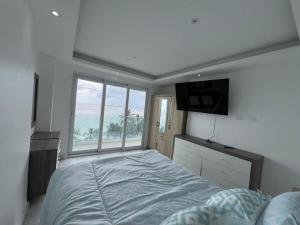 a bedroom with a large bed and a large window at Boca Beach 504, Boca Chica in Boca Chica +23 photos