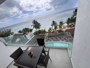 a balcony with a table and a view of the ocean at Boca Beach 504, Boca Chica in Boca Chica