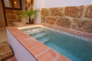 a pool in a room with a brick wall at Ca La Portella in Jávea