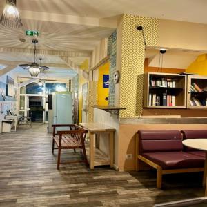 a waiting room with a table and chairs and a refrigerator at trendy hostel in Ivry-sur-Seine