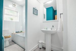 ein weißes Badezimmer mit Waschbecken, Badewanne und Toilette in der Unterkunft Central Sheffield Stadium House 15ppl Free Parking in Sheffield + 70 Fotos