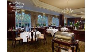 a restaurant with white tables and chairs and a chandelier at The Green Park Boutique Hotel and Grand Suites - Chapultepec Parkfront in Mexico City