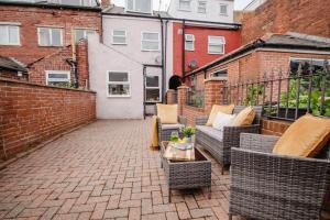 eine Terrasse mit Sofas und einem Tisch auf einem gemauerten Innenhof in der Unterkunft Central Sheffield Stadium House 15ppl Free Parking in Sheffield