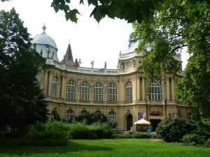 um grande edifício com um pátio verde em frente em Joe Apartman Budapest em Budapeste