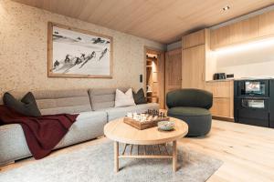a living room with a couch and a table at Apart Bieles NEU - Bergoase mit privater Outdoor-Sauna & Massagepraxis in Kauns