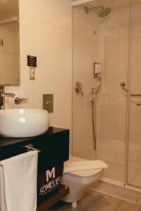 a bathroom with a shower and a toilet and a sink at Hotel Sommelier Agustinas in Santiago
