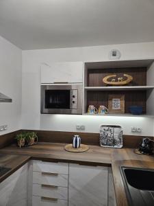a kitchen with a counter top with a microwave at Les Volets Bleus house and spa in Jublains