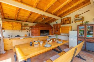 a kitchen with a wooden table and a refrigerator at Villa Kalura in Klanac