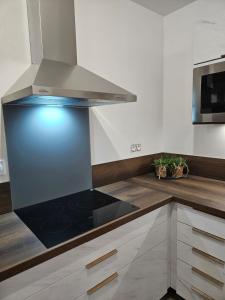 una cucina con piano cottura e forno di Les Volets Bleus house and spa a Jublains