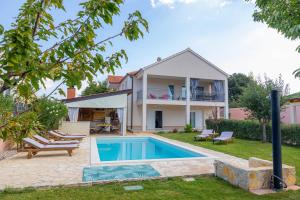 a house with a swimming pool in the yard at Villa Kalura in Klanac