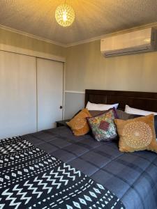 a bedroom with a large bed with colorful pillows at Onira, Where Nature Meets Soul in Santiago +17 photos