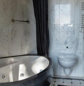 une salle de bain avec baignoire et toilettes dans l'établissement Pipowagen Bijzonder Buitenaf met jacuzzi en sauna, à Vragender 36 autres photos