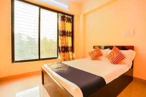 a bedroom with a bed with a large window at SPOT ON Pawan Villa in Gorhe