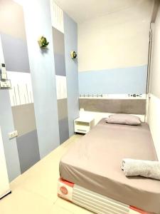 - une chambre avec un lit et un mur à rayures dans l'établissement Future Hostel Pattaya, à Nong Prue