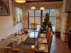 a dining room with a table and a christmas tree at Rupicapra Holiday Mountain House in Kostel +10 photos