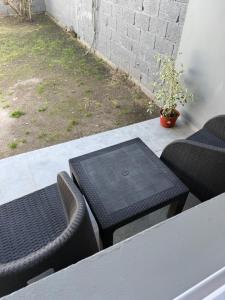 a table and chairs on a porch with a potted plant at Saladillo House in Saladillo