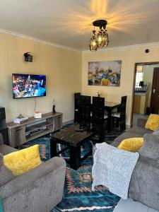 a living room with two couches and a table at Vane luxury Homes in Kisii