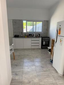 a kitchen with a refrigerator and a tile floor at Saladillo House in Saladillo
