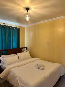 a bedroom with a white bed with a blue curtain at Vane luxury Homes in Kisii