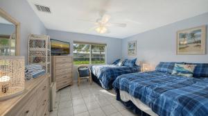 a bedroom with two beds and a television in it at Jamaica Royale #40 - 3 Heated Pools on the Beach! in Siesta Key +43 photos