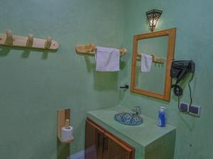 Un baño con lavabo, espejo y toallas. en Imlil Oasis -Oasis D'imlil -, en Imlil
