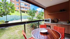 a kitchen with a table and chairs and a large window at Studio no Eco Resort Praia dos Carneiros - Serviços de Limpeza Diária in Tamandaré